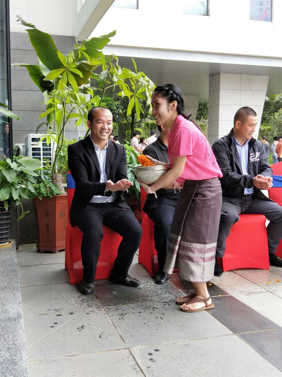 老撾駐廣西留學(xué)生代表將浸有花瓣的香水灑客人的手上，表示對(duì)嘉賓的美好祝福（圖一）