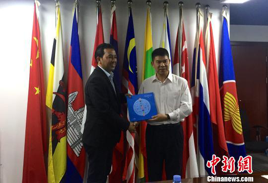 中國—東盟博覽會(huì)秘書處副秘書長黃平西（右）與柬埔寨新聞部新聞與傳播總司副總司長春占皮侖（左）互贈(zèng)禮物。