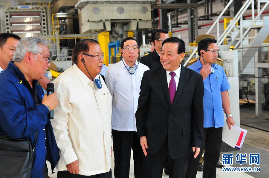 3月10日，在老撾沙灣拿吉省車邦縣，老撾人民革命黨中央總書記、國家主席本揚（左二）在山東太陽紙業(yè)股份有限公司董事長李洪信（右二）的陪同下視察公司。 新華社記者章建華攝